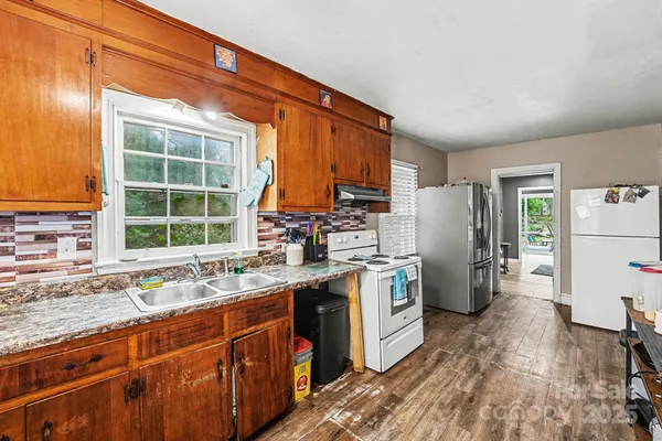 a kitchen with refrigerator a sink dishwasher a stove and a refrigerator with wooden floor