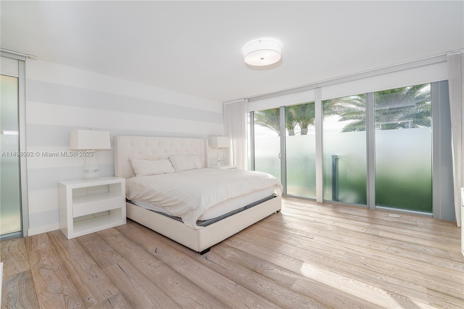 9501 Collins Avenue, Unit 1 Surfside, FL 33154 - Photo 14 of 35 a bedroom with a bed and a large window