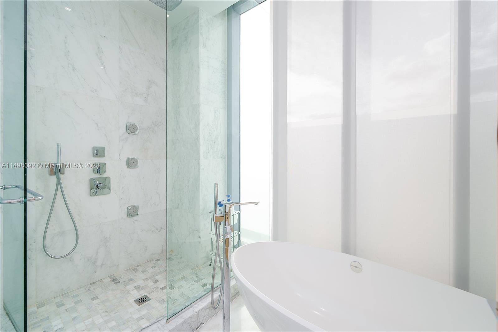 9501 Collins Avenue, Unit 1 Surfside, FL 33154 - Photo 16 of 35 a bathroom with a granite countertop shower and a sink