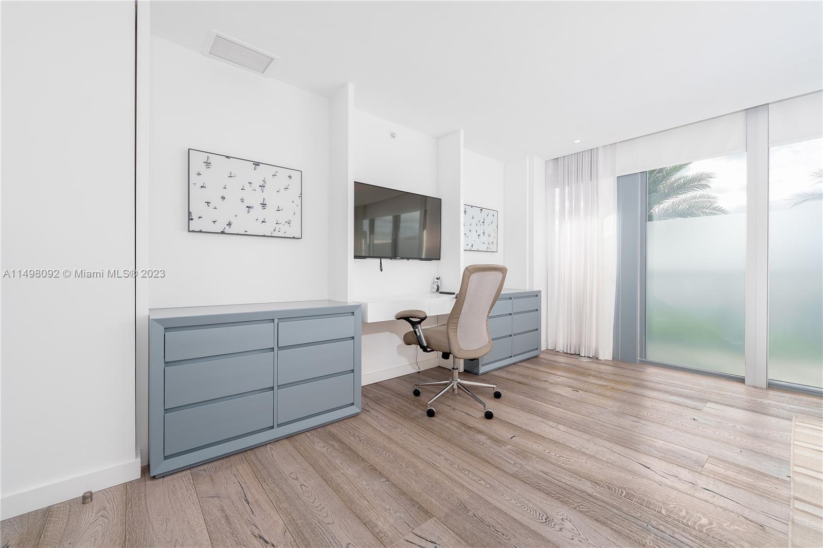 9501 Collins Avenue, Unit 1 Surfside, FL 33154 - Photo 17 of 35 a view of a workspace with furniture and a flat screen tv