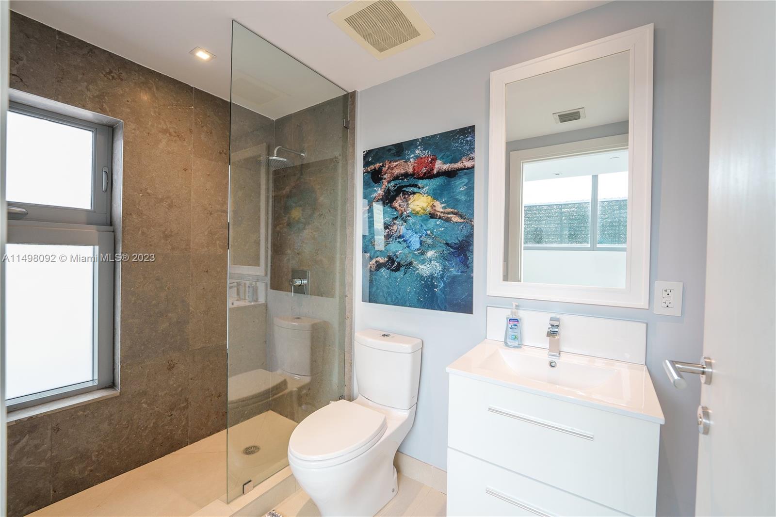 9501 Collins Avenue, Unit 1 Surfside, FL 33154 - Photo 18 of 35 a bathroom with a sink a toilet and shower