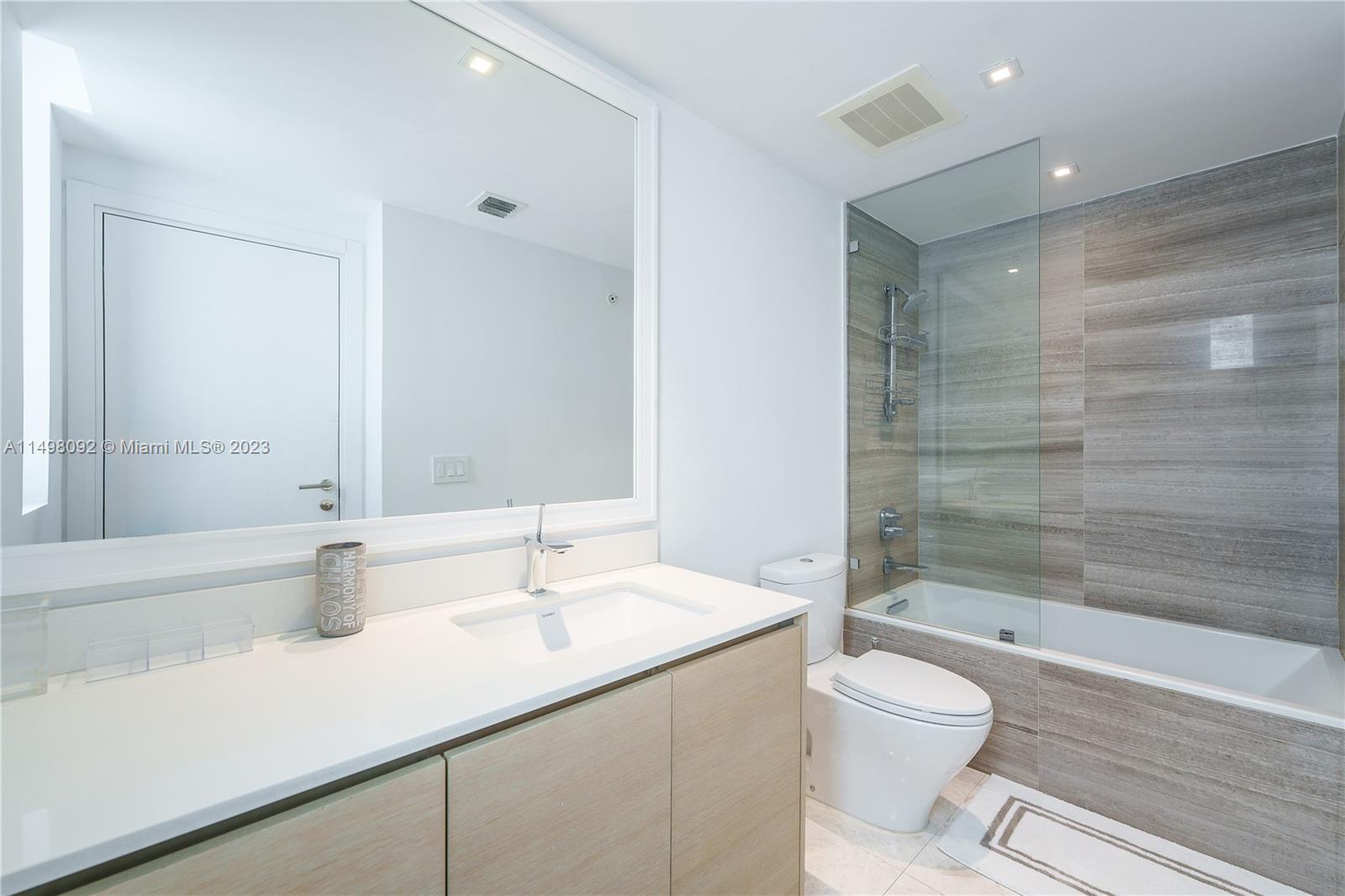 9501 Collins Avenue, Unit 1 Surfside, FL 33154 - Photo 21 of 35 a bathroom with a sink a toilet and shower