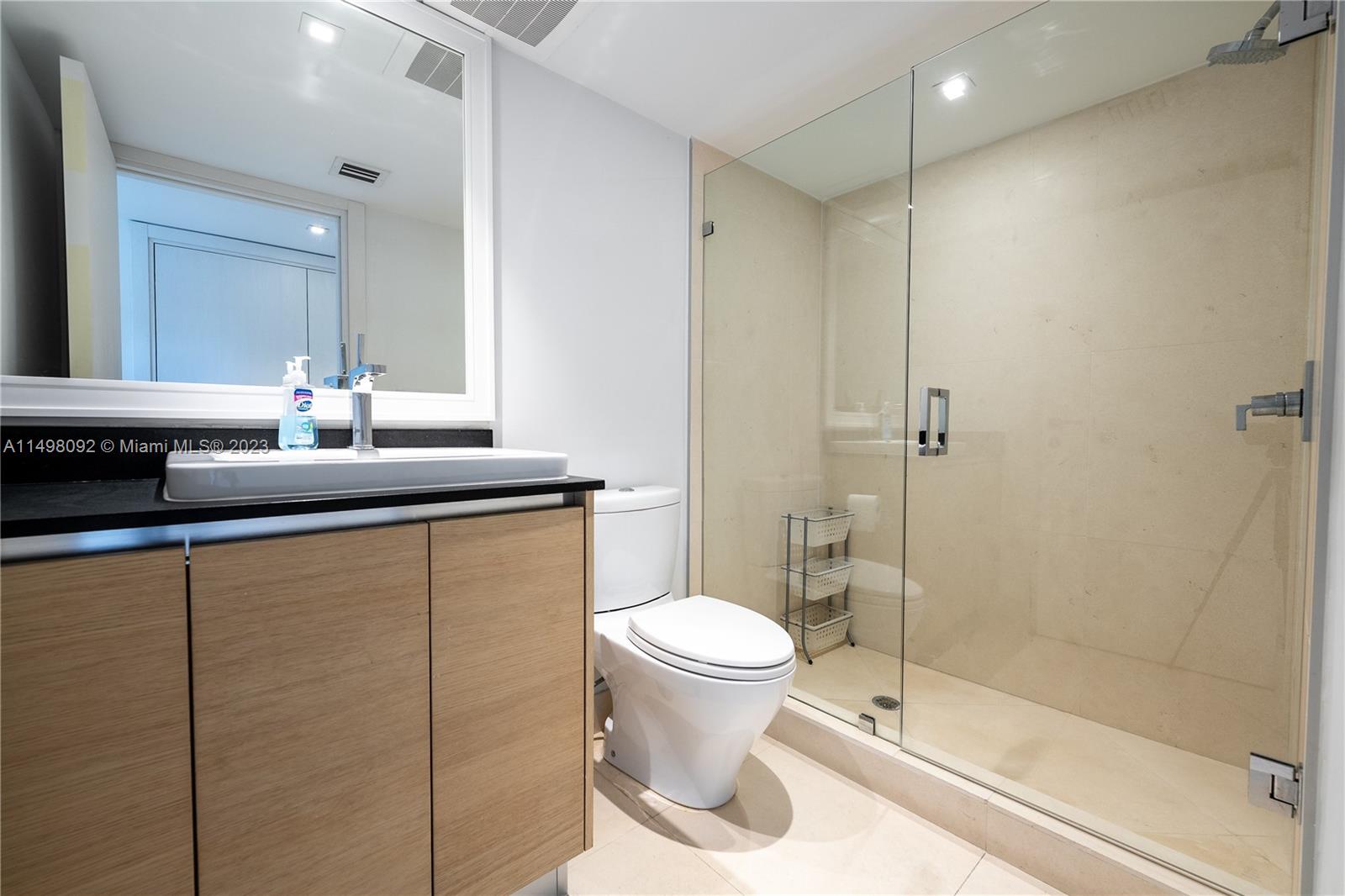 9501 Collins Avenue, Unit 1 Surfside, FL 33154 - Photo 22 of 35 a bathroom with a granite countertop sink toilet and shower