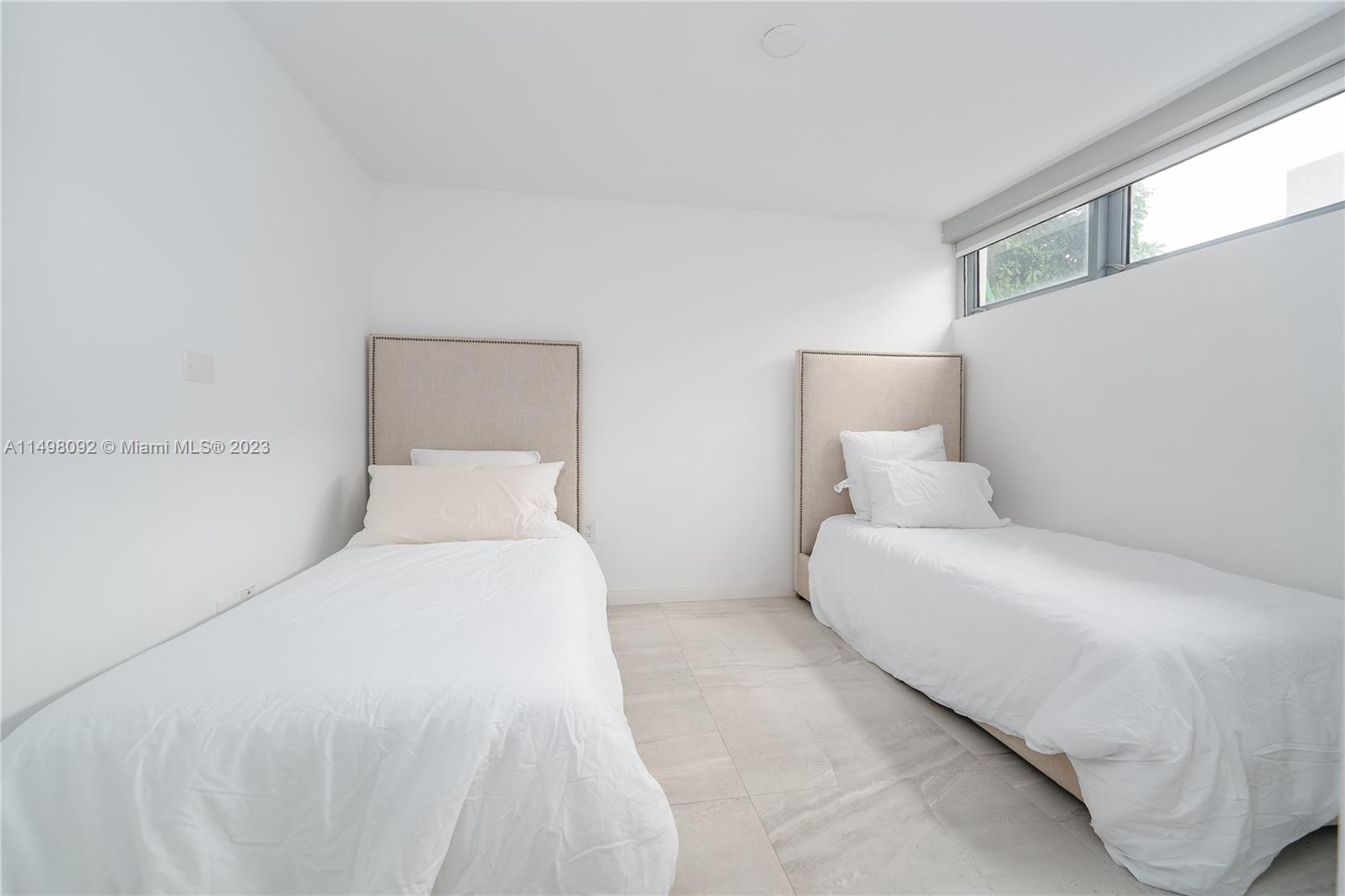 9501 Collins Avenue, Unit 1 Surfside, FL 33154 - Photo 23 of 35 a bedroom with a bed and a large window