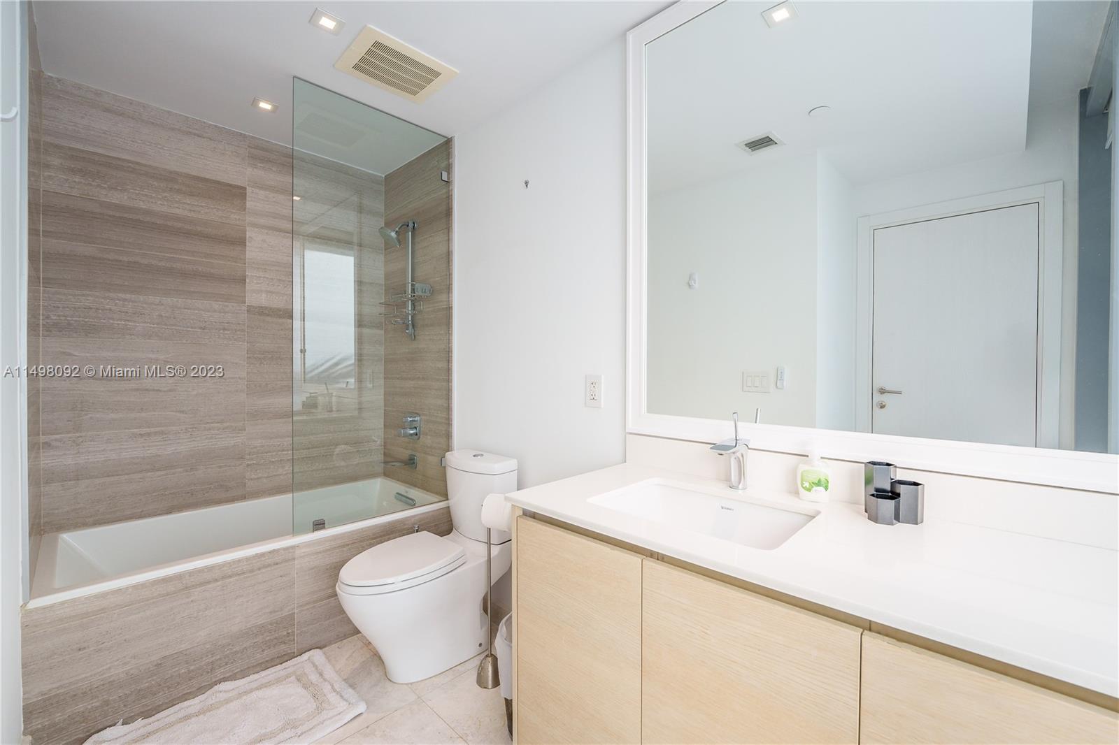 9501 Collins Avenue, Unit 1 Surfside, FL 33154 - Photo 24 of 35 a bathroom with a sink and a mirror