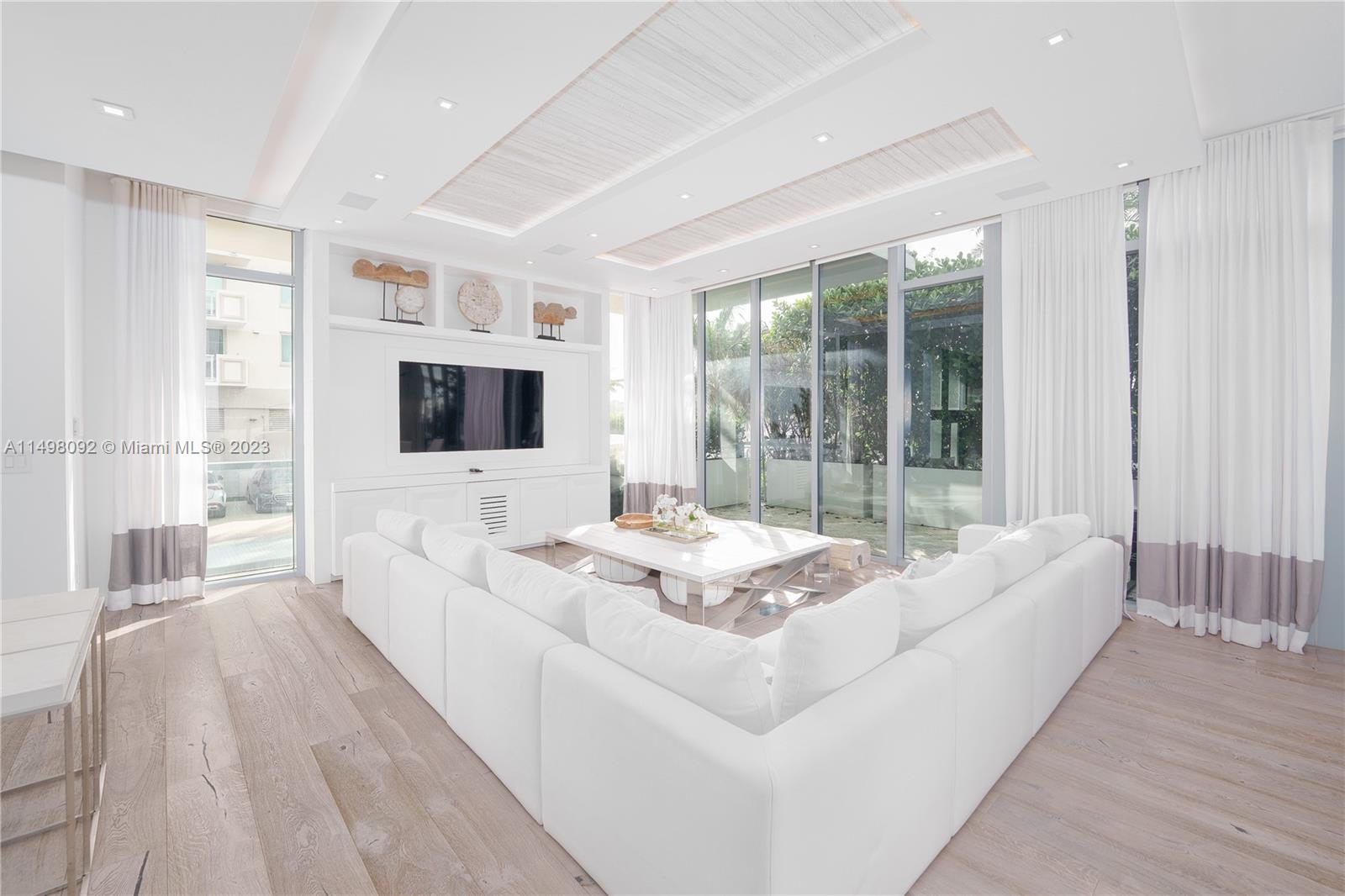 9501 Collins Avenue, Unit 1 Surfside, FL 33154 - Photo 3 of 35 a living room with furniture windows and a flat screen tv