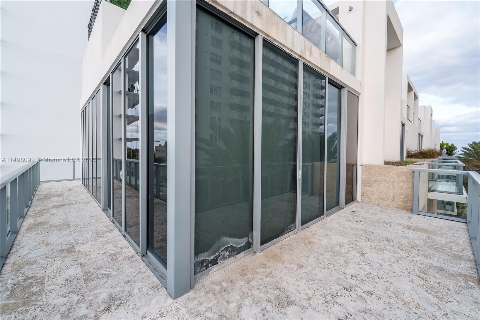9501 Collins Avenue, Unit 1 Surfside, FL 33154 - Photo 32 of 35 a view of a porch with wooden floor and a balcony