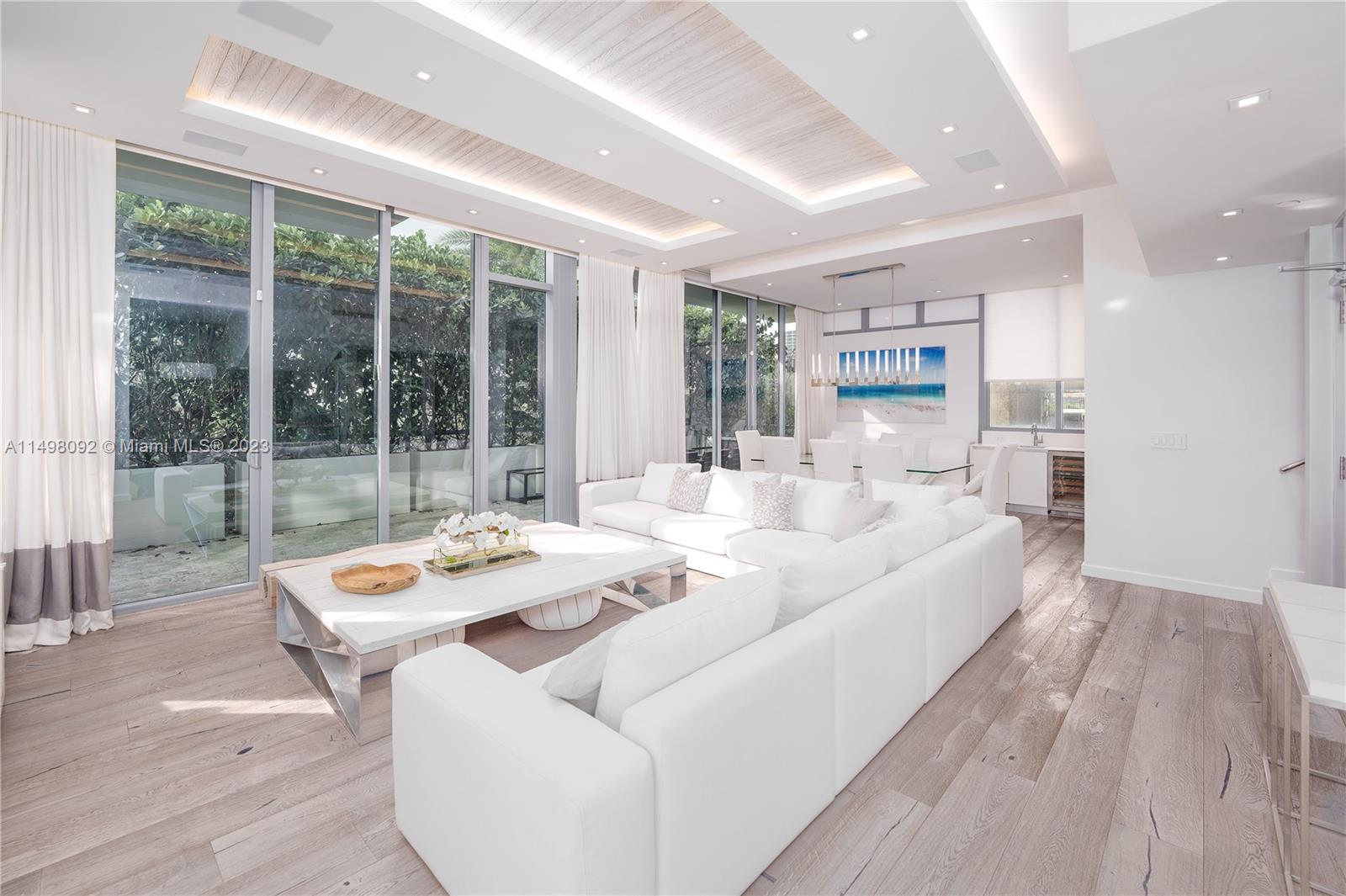 9501 Collins Avenue, Unit 1 Surfside, FL 33154 - Photo 4 of 35 a living room with furniture and large windows