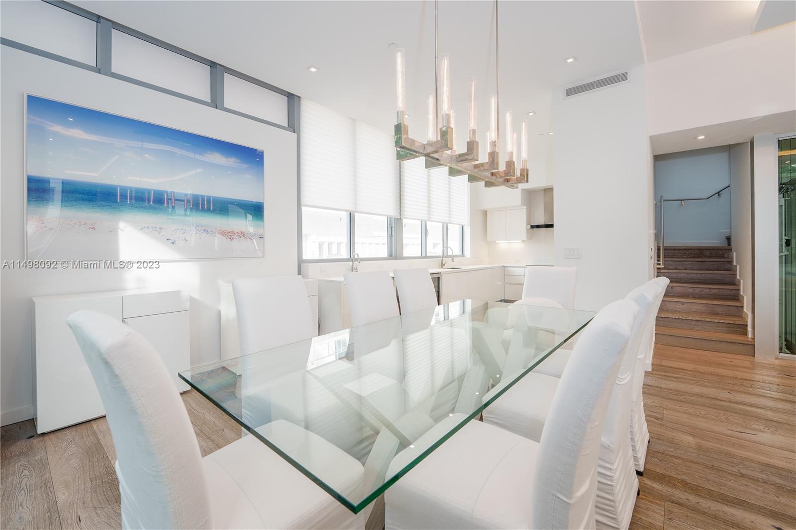 9501 Collins Avenue, Unit 1 Surfside, FL 33154 - Photo 5 of 35 a dining room with furniture and wooden floor