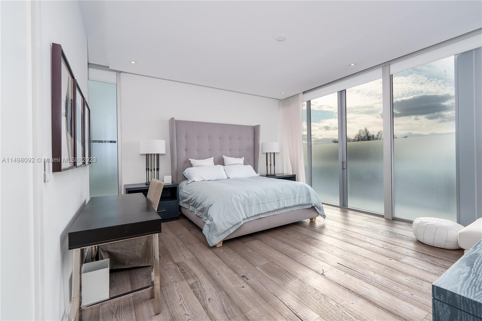 9501 Collins Avenue, Unit 1 Surfside, FL 33154 - Photo 9 of 35 a bedroom with a bed and wooden floor