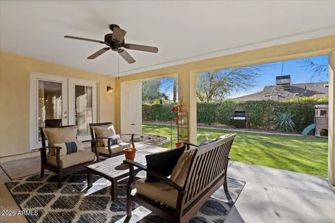 a living room with patio furniture and a floor to ceiling window