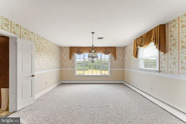 a view of an entryway wooden floor and a chandelier