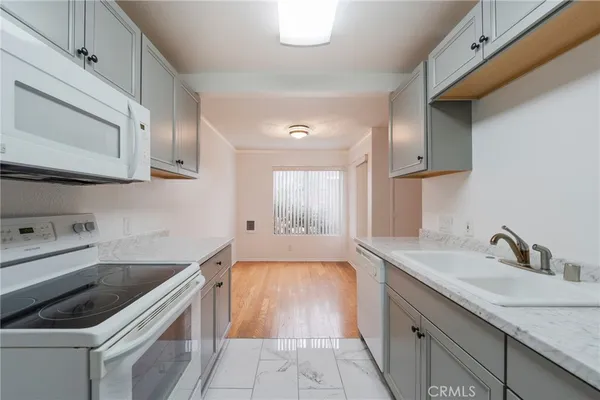 a kitchen with granite countertop a sink stove and cabinets