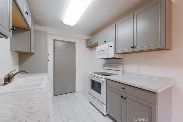 a kitchen with a stove sink and cabinets