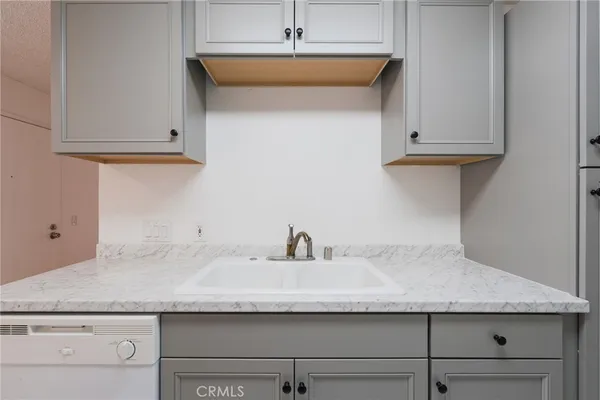 a kitchen with granite countertop a sink and cabinets