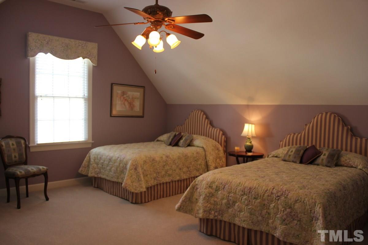 7405 Fontana Ridge Lane Raleigh, NC 27613 - Photo 12 of 25 a bedroom with two beds and a chandelier