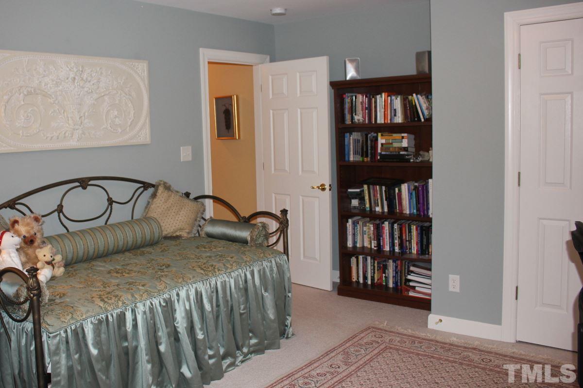 7405 Fontana Ridge Lane Raleigh, NC 27613 - Photo 15 of 25 a bedroom with a bed a book shelf and a window