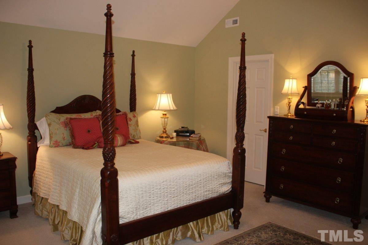 7405 Fontana Ridge Lane Raleigh, NC 27613 - Photo 16 of 25 a bedroom with a bed and a dresser