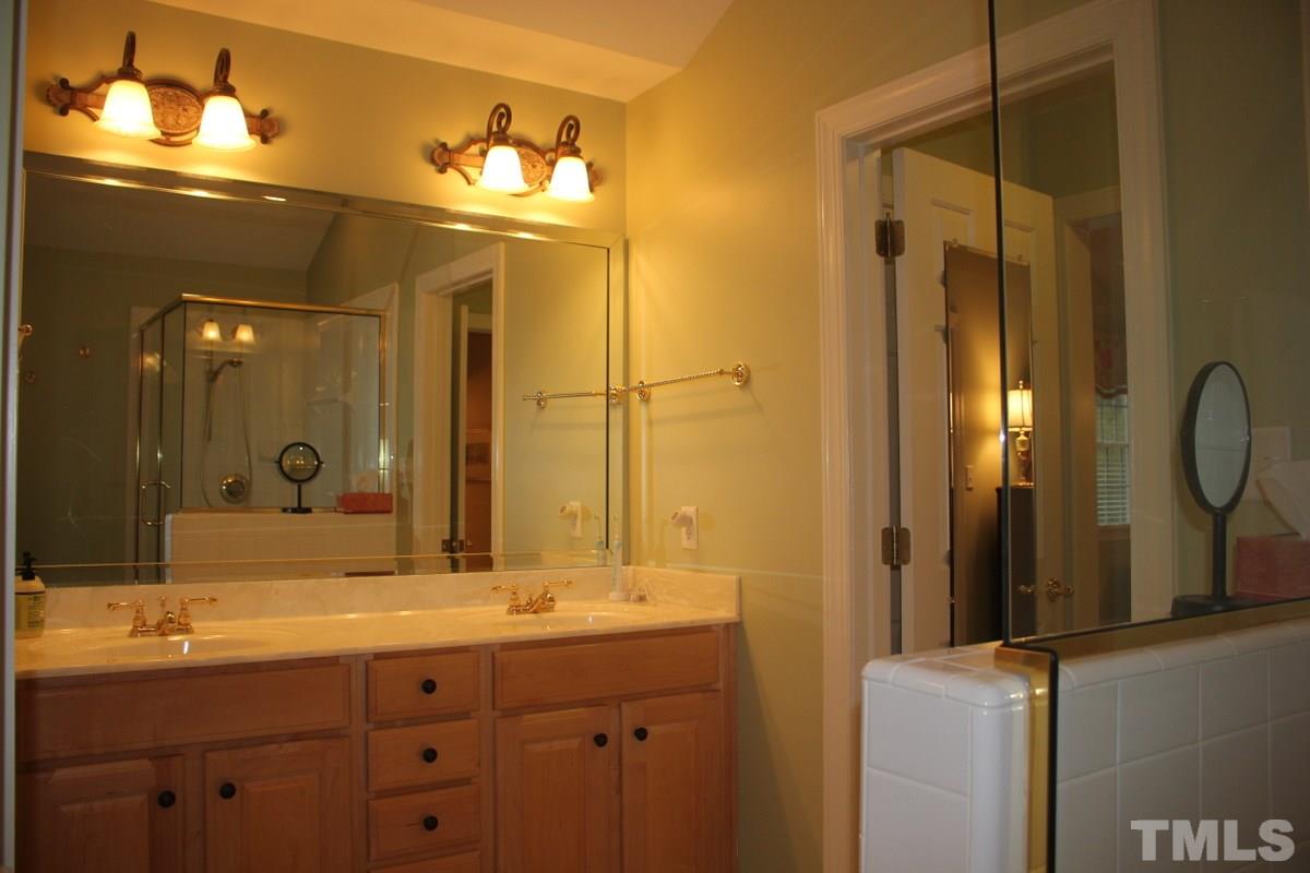 7405 Fontana Ridge Lane Raleigh, NC 27613 - Photo 19 of 25 a bathroom with a double vanity sink and a mirror