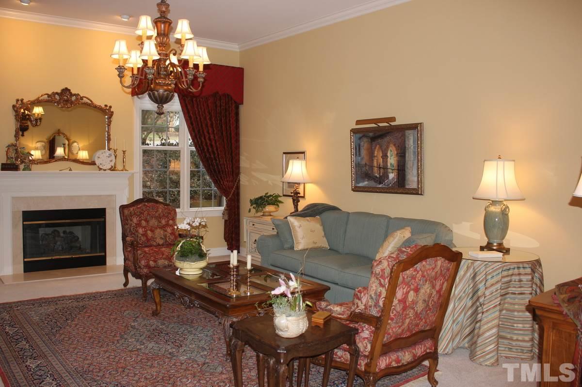 7405 Fontana Ridge Lane Raleigh, NC 27613 - Photo 4 of 25 a living room with furniture a fireplace and a chandelier