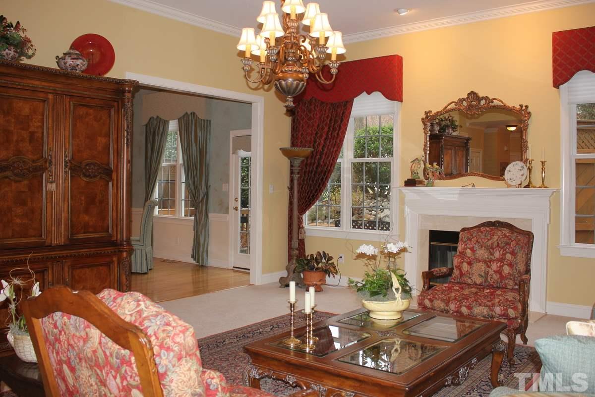 7405 Fontana Ridge Lane Raleigh, NC 27613 - Photo 25 of 25 a living room with furniture a fireplace and a chandelier