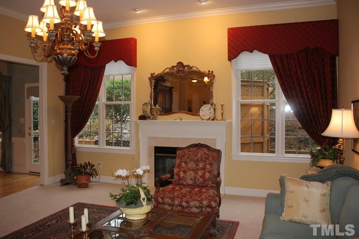 7405 Fontana Ridge Lane Raleigh, NC 27613 - Photo 5 of 25 a living room with furniture a fireplace and a chandelier