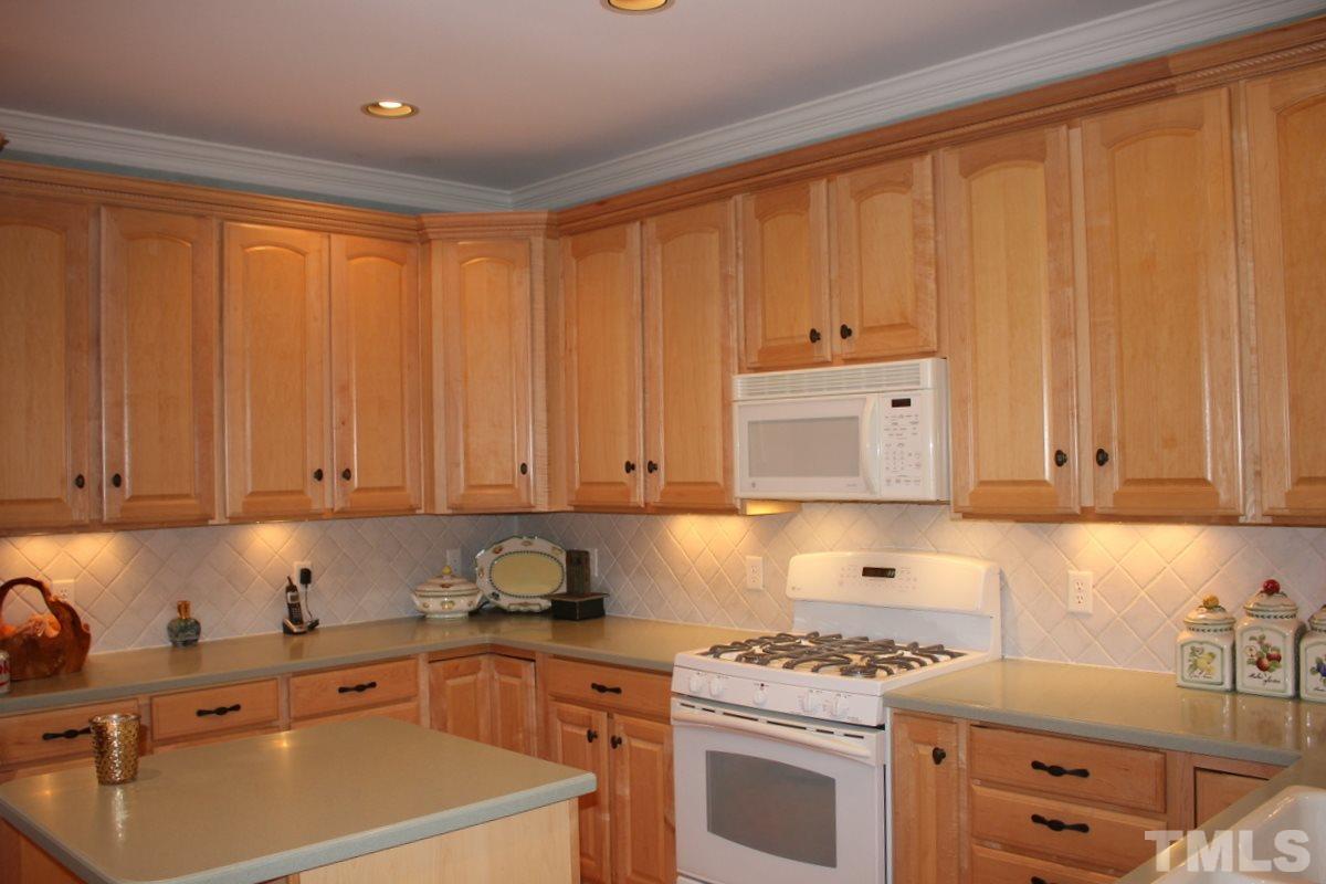 7405 Fontana Ridge Lane Raleigh, NC 27613 - Photo 7 of 25 a kitchen with granite countertop stainless steel appliances a stove a sink and white cabinets