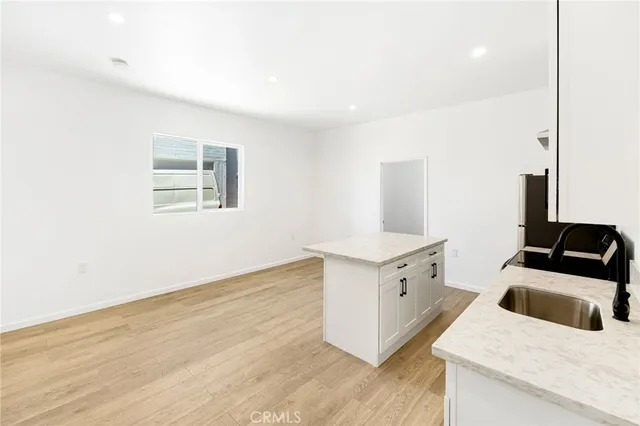 a kitchen with granite countertop white cabinets and white appliances