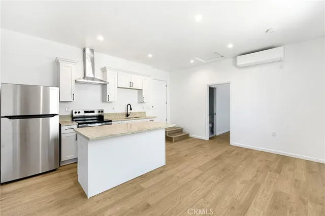 a kitchen with stainless steel appliances granite countertop a refrigerator a stove and a sink