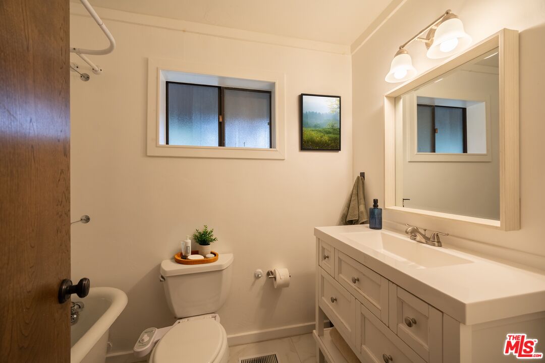 26645 Lake Forest Drive Twin Peaks, CA 92391 - Photo 17 of 30 a bathroom with a granite countertop toilet a sink and mirror