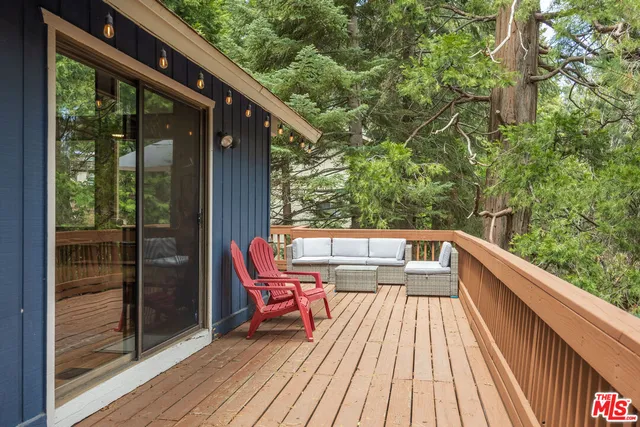 a balcony with wooden floor and outdoor seating