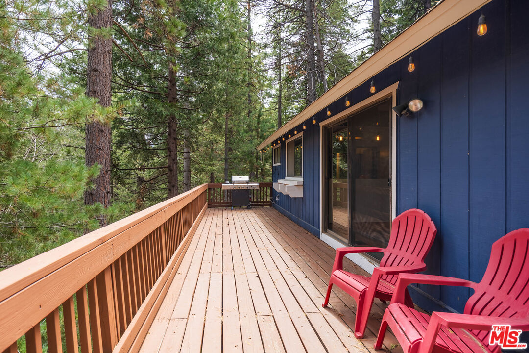 26645 Lake Forest Drive Twin Peaks, CA 92391 - Photo 27 of 30 a balcony with wooden floor and outdoor seating