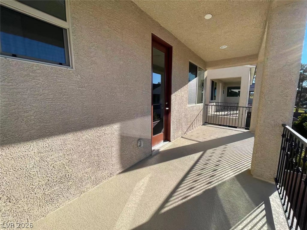 11 Rancho Maria Street Las Vegas, NV 89148 - Photo 18 of 27 Shaded concrete balcony area features stucco walls and recessed lighting.