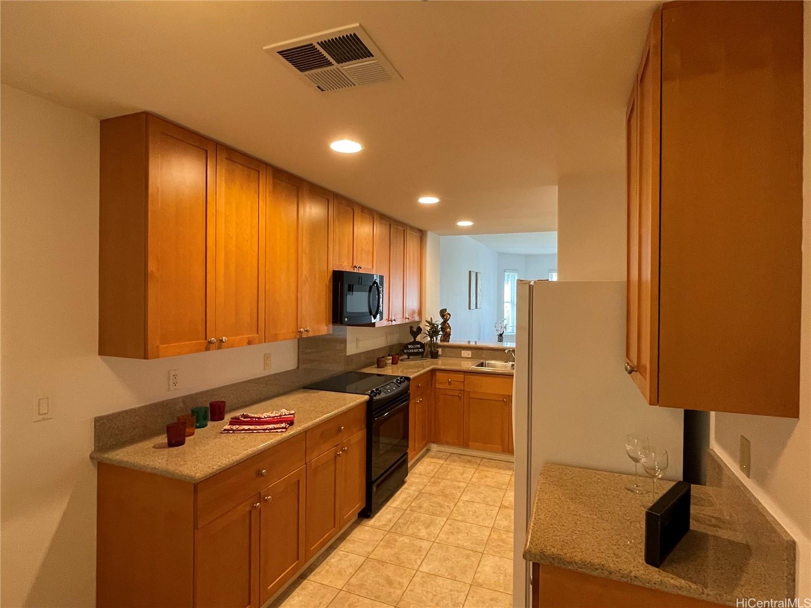 520 Lunalilo Home Road, Unit 8225 Honolulu, HI 96825 - Photo 2 of 25 a kitchen with refrigerator and cabinets