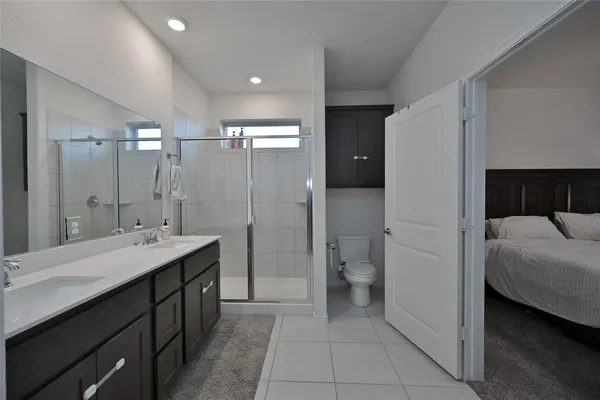 a bathroom with a double vanity sink toilet and shower
