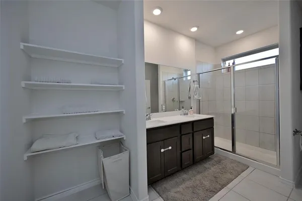 a bathroom with a double vanity sink a toilet and shower