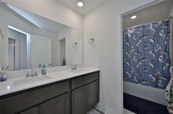 a bathroom with a double vanity sink mirror and shower