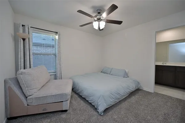 a bedroom with a bed chandelier and a couch