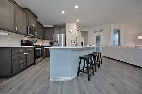 a kitchen with stainless steel appliances granite countertop wooden floors and cabinets