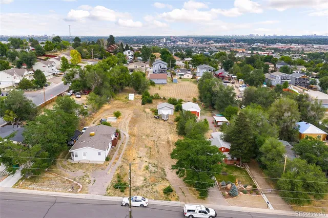an aerial view of residential houses with outdoor space and trees