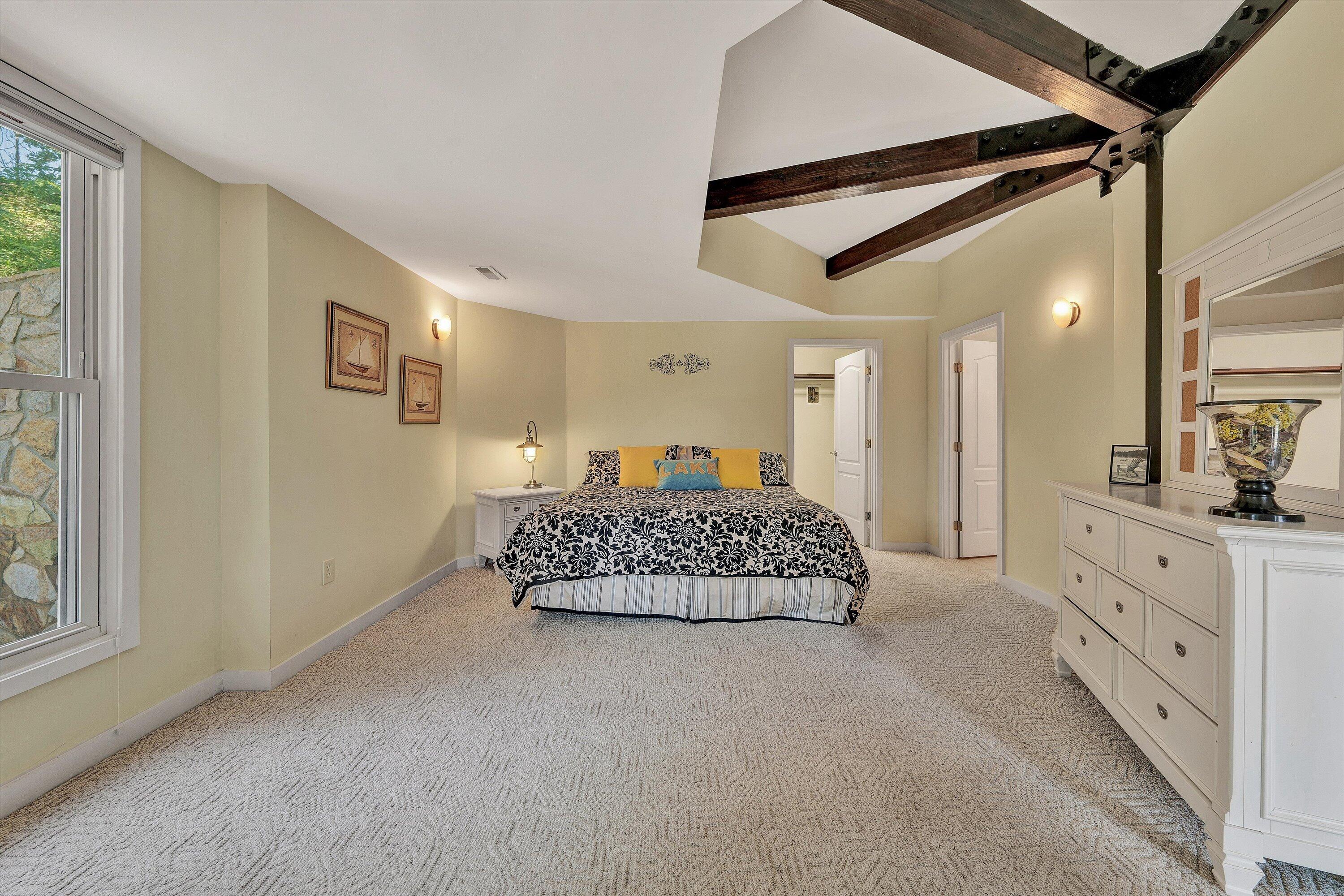 207 Winding Way Union Hall, VA 24176 - Photo 36 of 60 a spacious bedroom with a bed and a chandelier