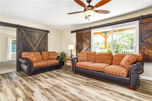 a view of a livingroom with wooden floor and a large window