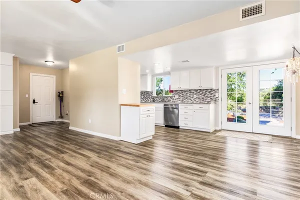 a kitchen with granite countertop white cabinets and stainless steel appliances