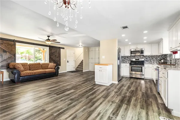 a kitchen with stainless steel appliances granite countertop white cabinets and a stove a oven with white countertops