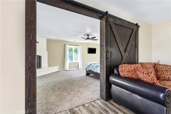a view of a hallway with wooden floor and cabinet