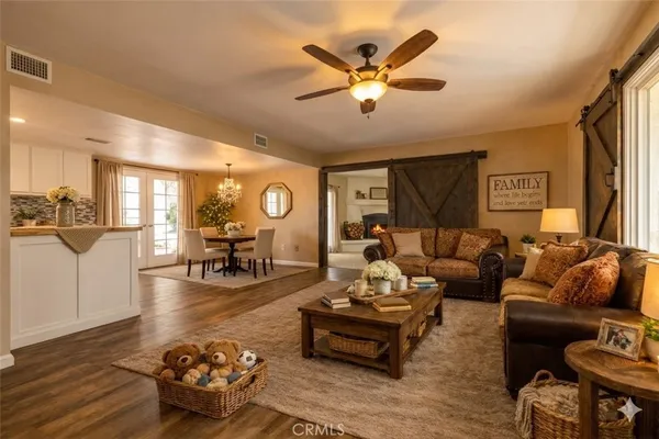 a large white kitchen with a white countertops a stove a dining table and chairs with wooden floor