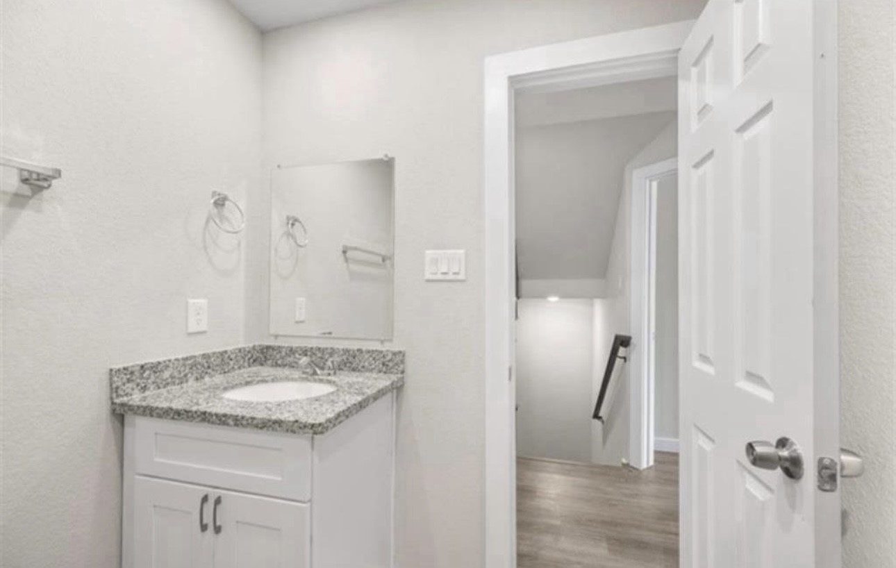 6801 Haight Street, Unit B Houston, TX 77028 - Photo 2 of 8 a bathroom with a granite countertop sink and a mirror