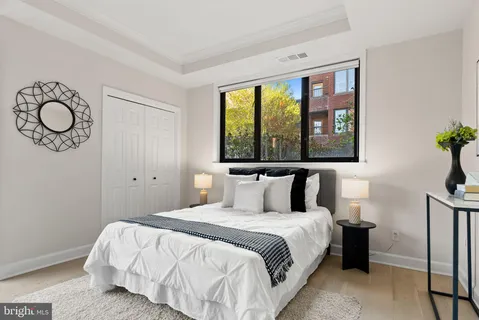a bedroom with a bed and a large window