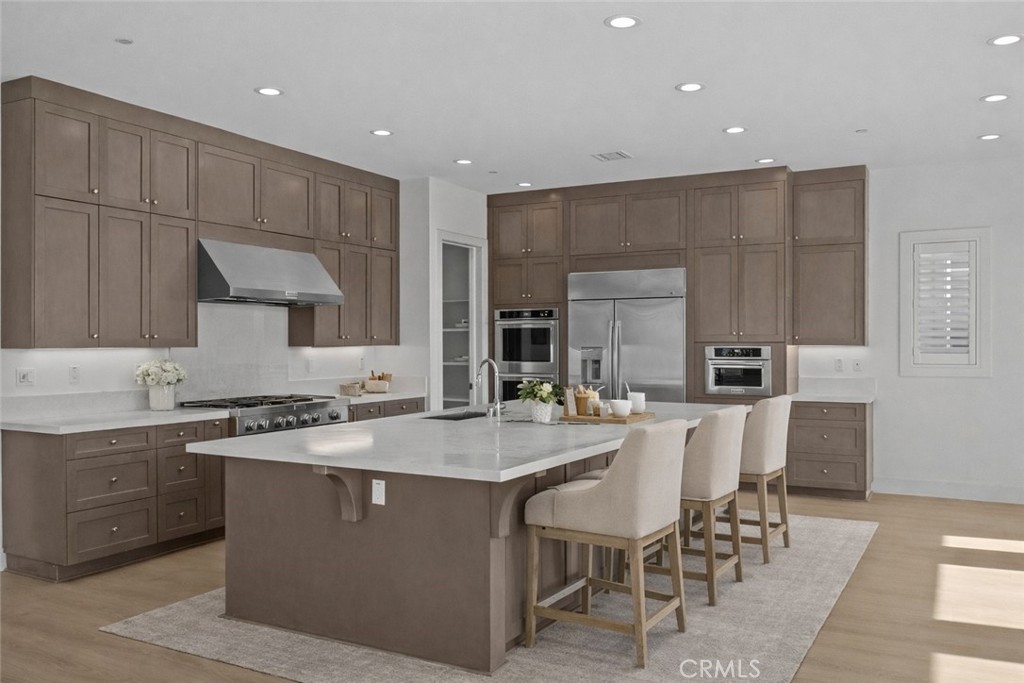 20638 Deer Grass Court Porter Ranch, CA 91326 - Photo 5 of 50 a kitchen with a stove a sink a dining table and chairs