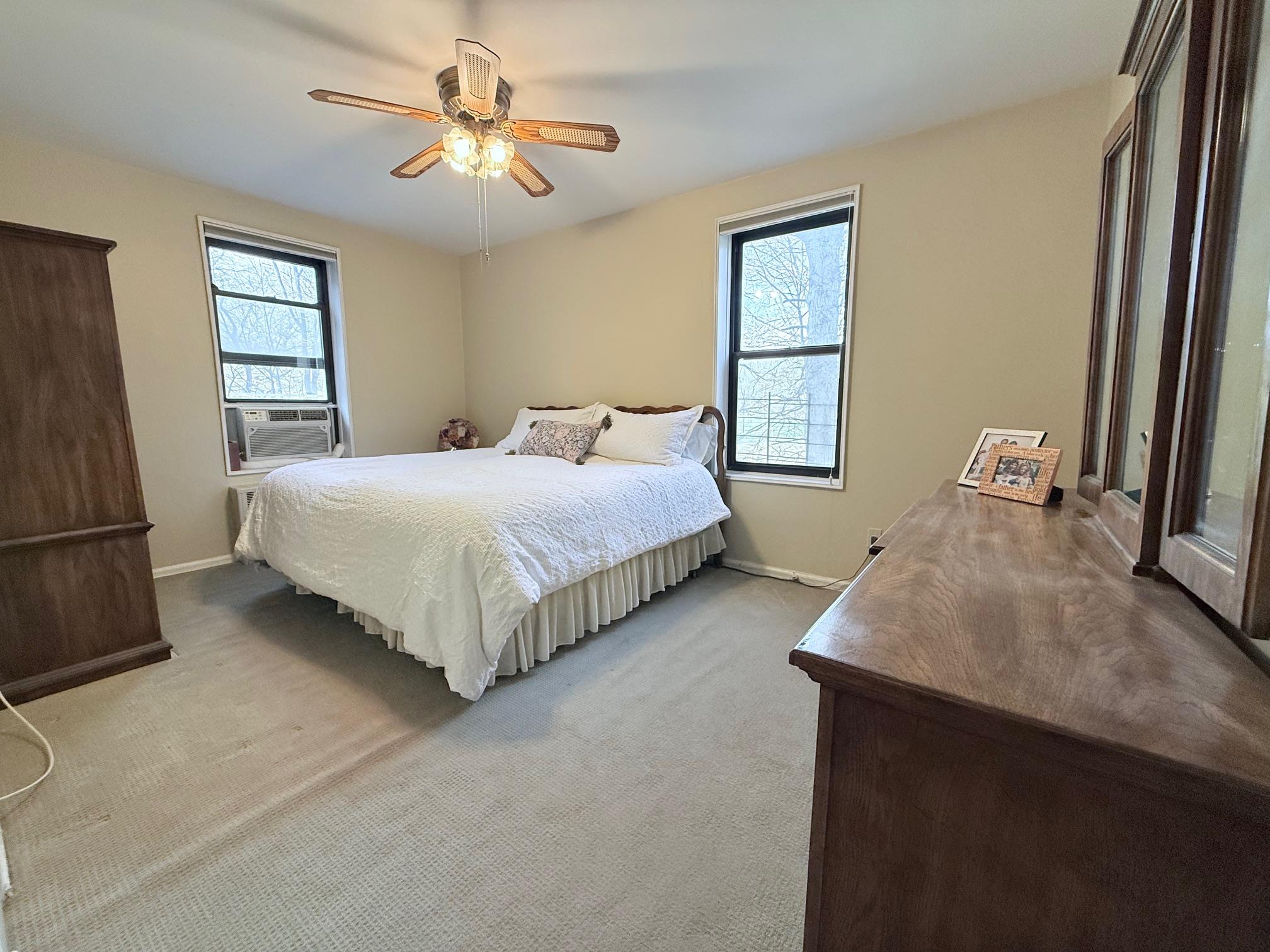 83-15 98th Street, Unit 3C Queens, NY 11421 - Photo 7 of 12 a bedroom with a bed and a chandelier